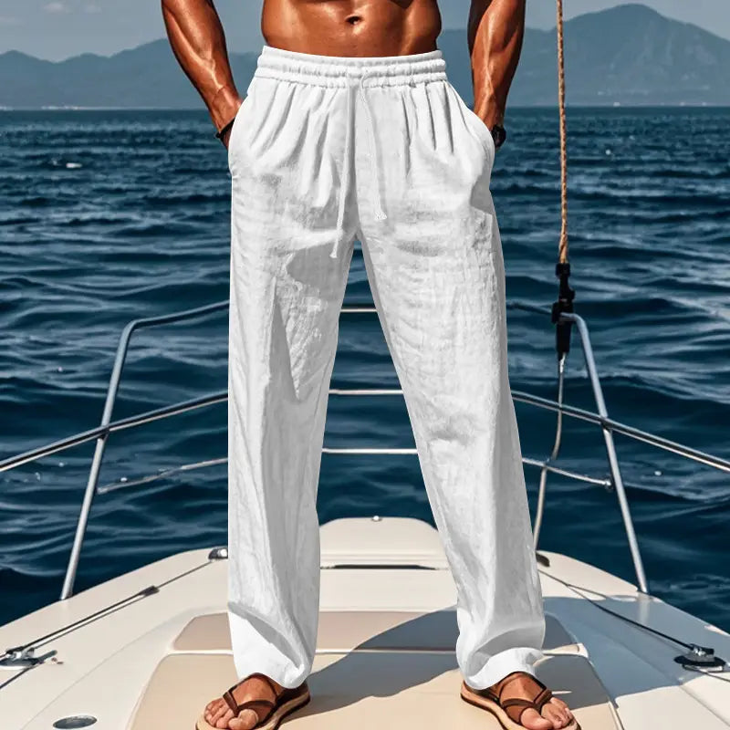 White linen trousers with an elastic waistband and drawstring featuring a relaxed fit for casual wear.