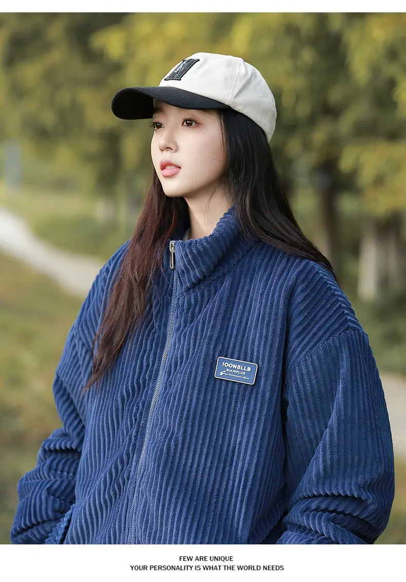 Herren Cord-Pufferjacke in Blau mit Reißverschluss vorne und kleinem rechteckigem Aufnäher auf der linken Brust, entworfen für winterliche Wärme.