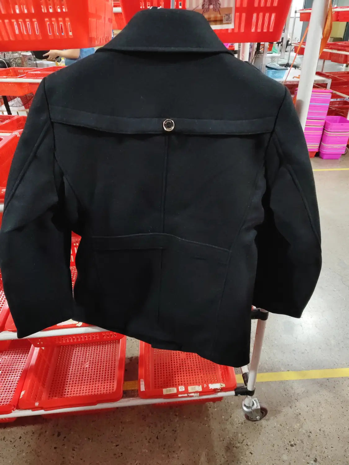 Black woolen trench coat for men shown from the back with a structured collar and a single button detail.