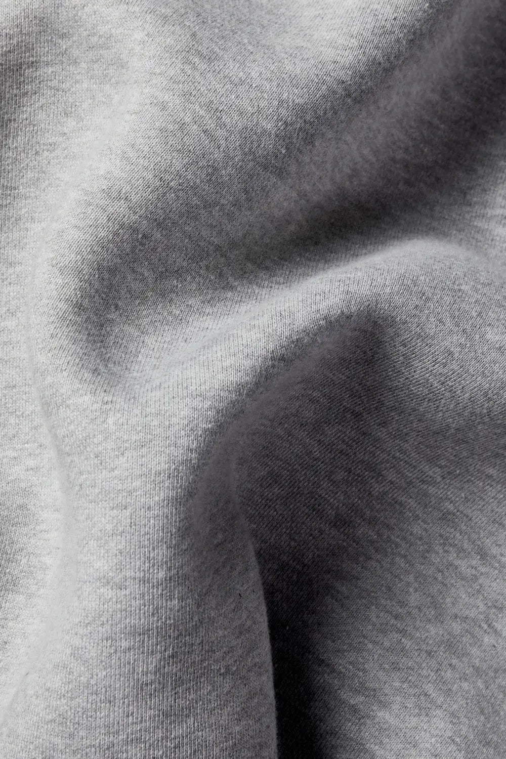 A soft heather gray fleece sweatpants unisex elastic waist joggers made of knit fabric with subtle texture and gentle folds.