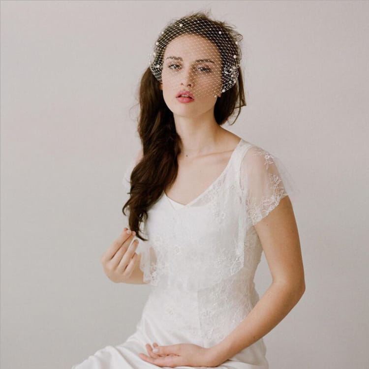 Short pearl beaded mesh bridal veil features delicate white lace adorned with small pearl embellishments and includes a gold hair comb.