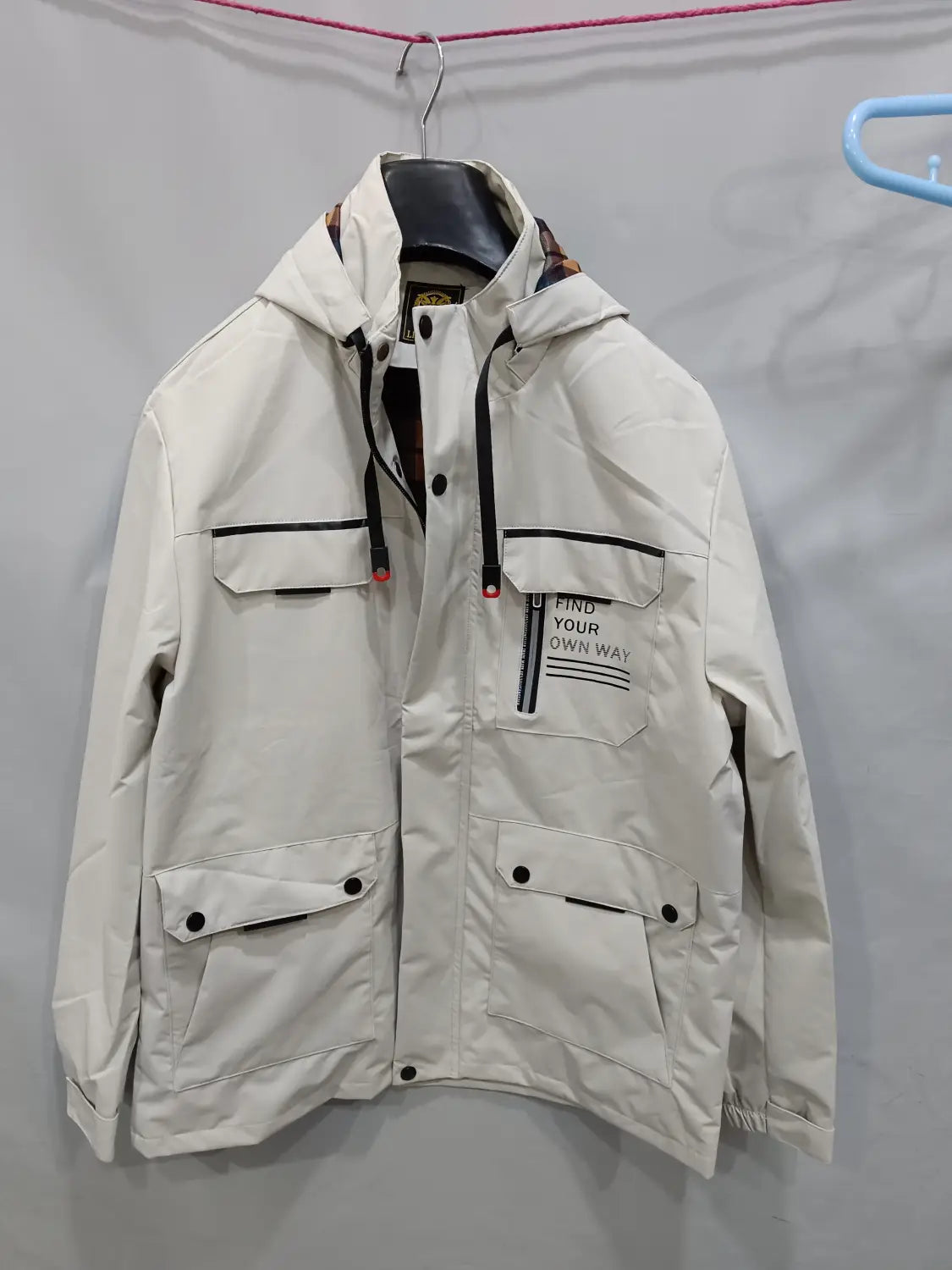 Men winter hooded parka coat in off-white with black trim featuring button closures and a front pocket patch reading find your own way.