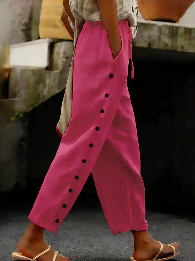 Cropped patchwork button casual pants for women in bright pink featuring loose-fitting design and black buttons running down the side seam.