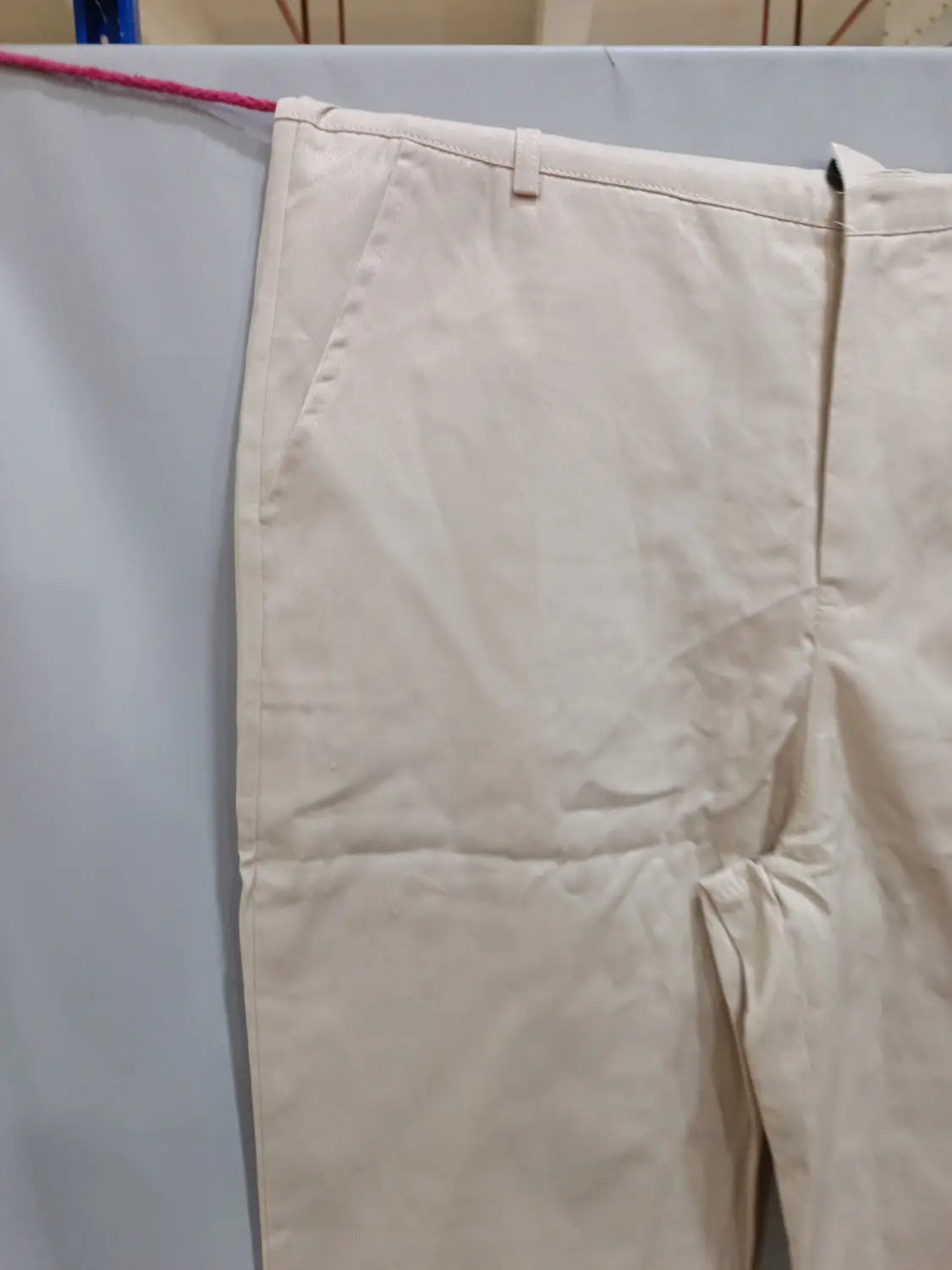 Beige men’s casual slim fit chinos with a clean tailored fit and visible stitching details.