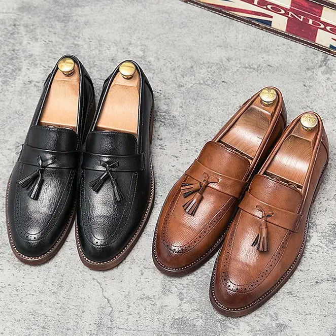 Un par de mocasines estilo brogue con borlas en cuero negro y marrón para hombre con suela de goma.