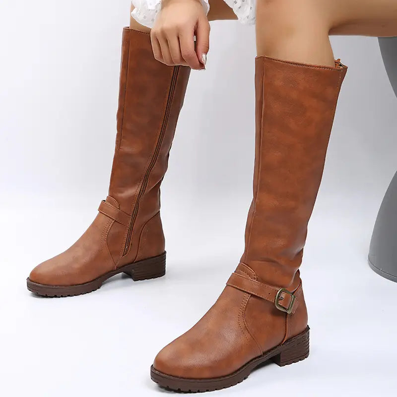 brown leather knee high knight boots with a buckle strap and low block heel shown from the back side