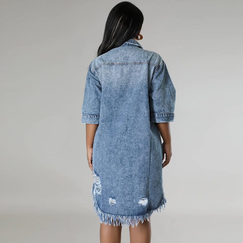 Robe chemise midi en denim, en lavage bleu délavé, avec manches trois-quarts et un ourlet effiloché abîmé.