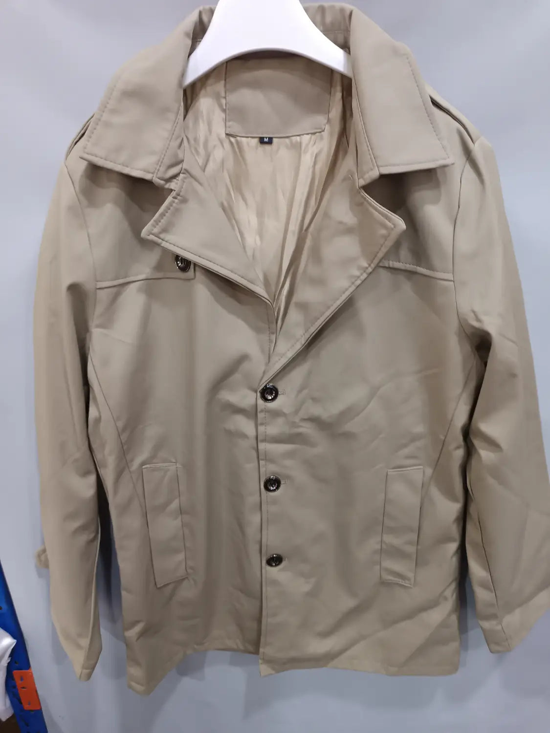 Trench-coat d’affaires homme slim beige, avec un col structuré, une fermeture frontale boutonnée et deux poches latérales.