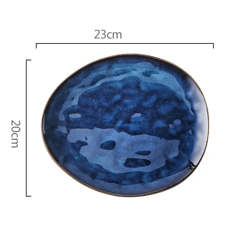 A round ceramic plate from a ceramic coffee mug and saucer set featuring a deep blue mottled glaze with a subtle metallic rim.