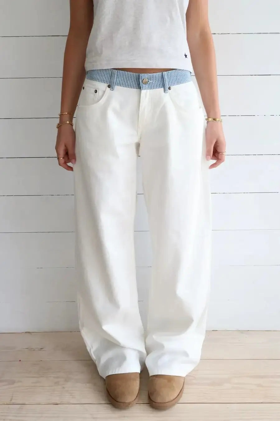 Pantalon en denim blanc à jambes larges avec une ceinture rayée bleu et blanc, pour un look élégant.