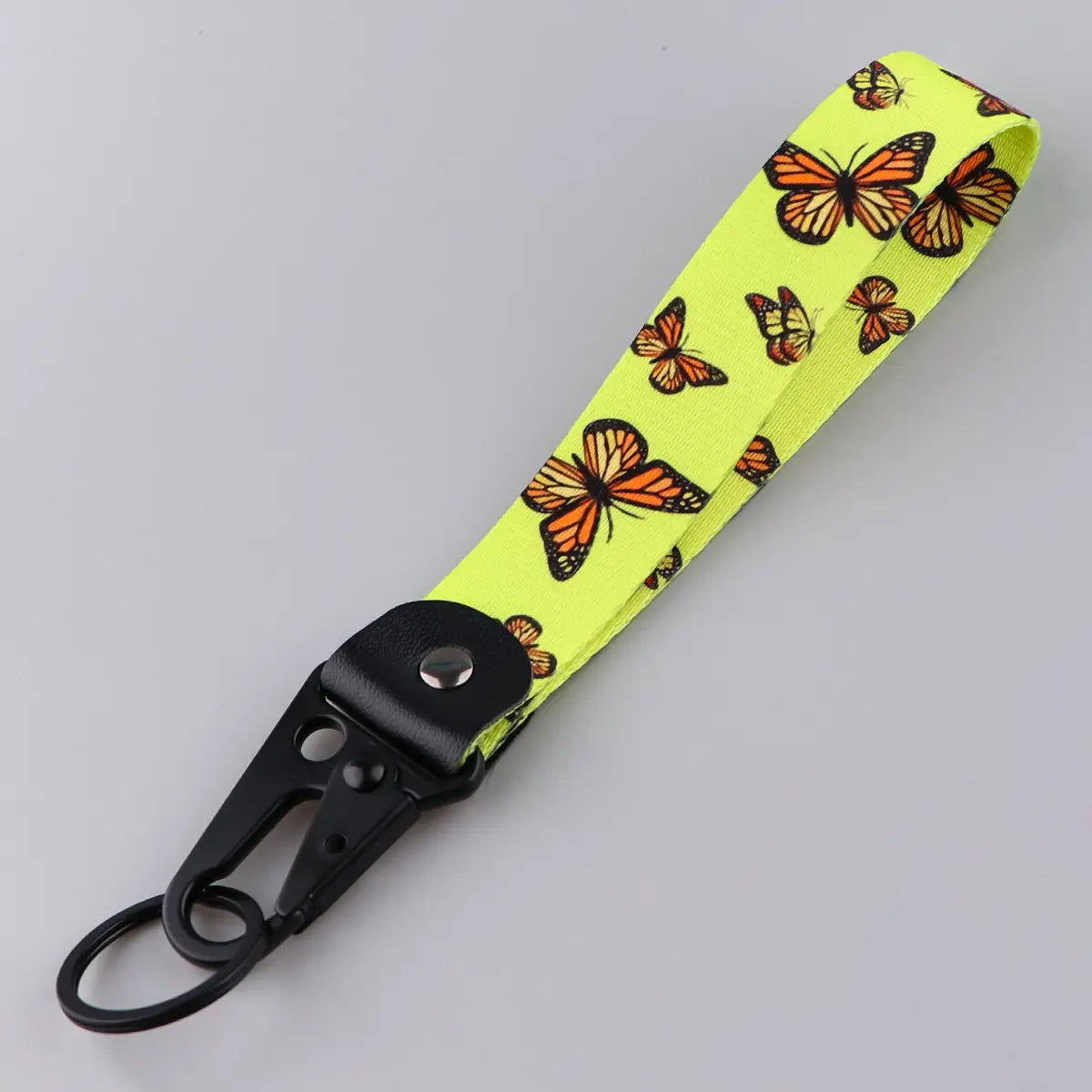 A bright neon yellow butterfly wrist strap keychain with orange and black monarch butterfly pattern attached to a black metal carabiner clip.