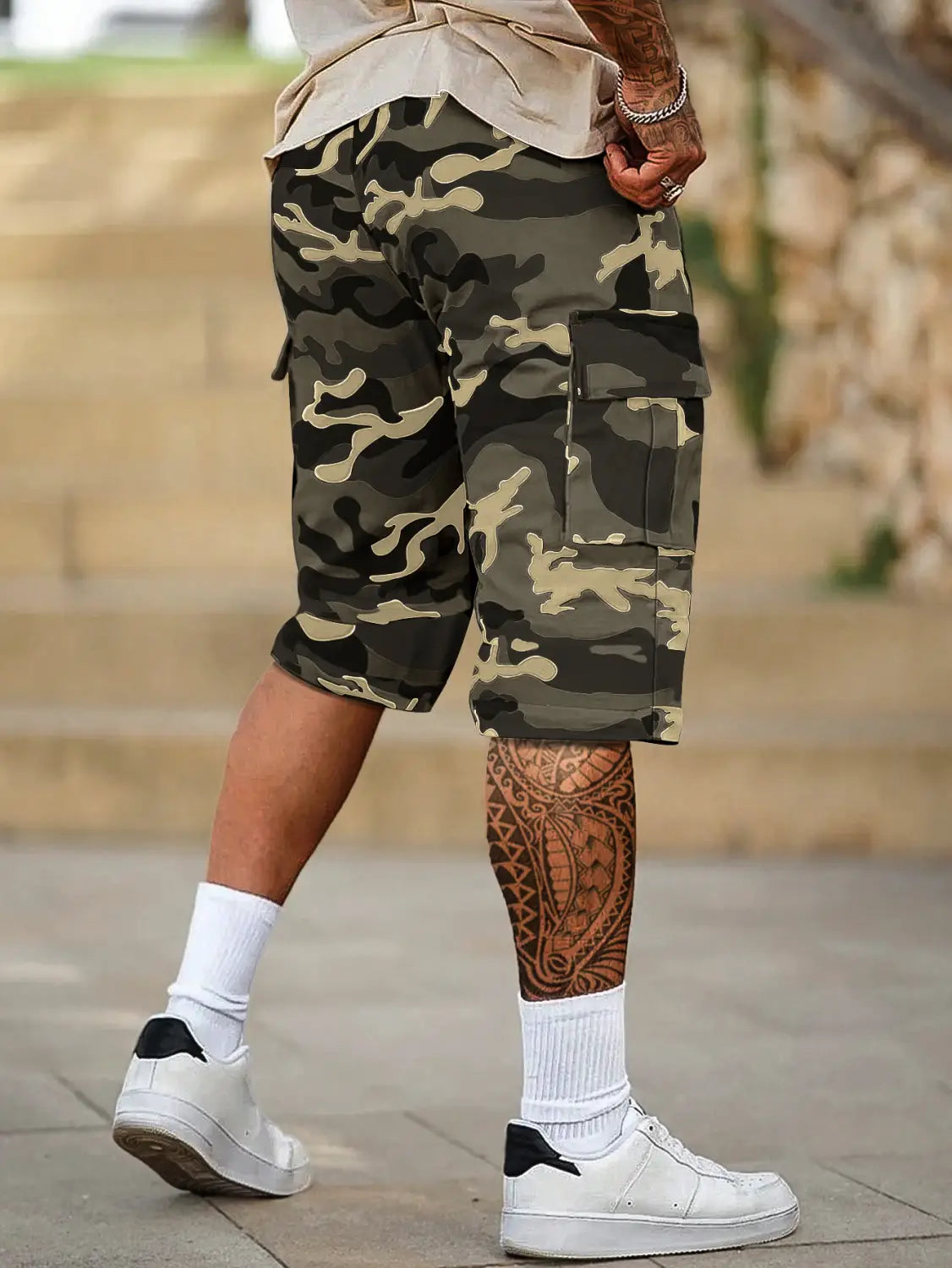 Short cargo camouflage pour homme, coupe ample, en tons olive et beige, présentant plusieurs poches pour plus de fonctionnalité.