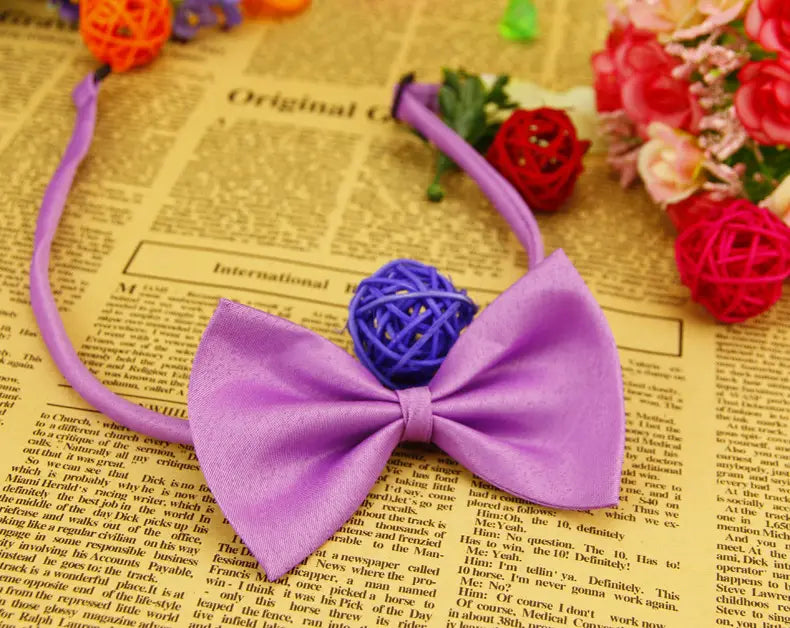 Collar para mascotas de color sólido ajustable que presenta un moño tipo corbata tejido morado con un nudo esférico central azul.
