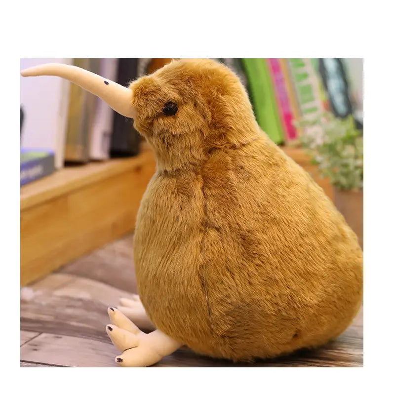 柔らかな茶色の毛並み、長いベージュのくちばし、小さな黒い目を備えた、やわらかなキウイバードのぬいぐるみ。ふわふわのぬいぐるみキーチェーンとしてデザインされています。