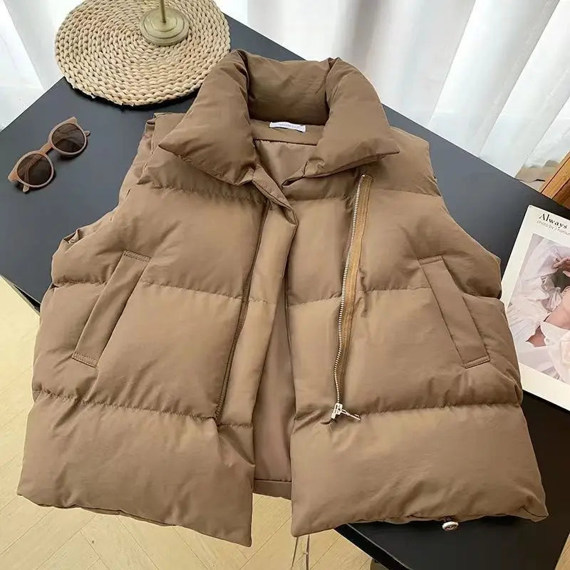 A cozy tan-colored women quilted puffer vest featuring a plush collar and front zipper closure for loose sleeveless outerwear.