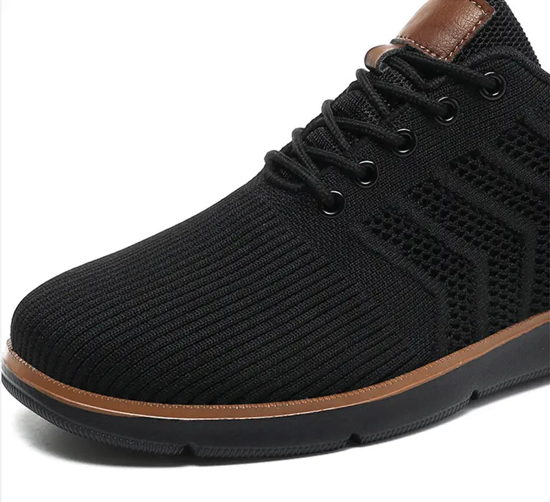 Black knit mesh sneaker for men with brown leather accents and matching sole designed for casual flying woven shoes.