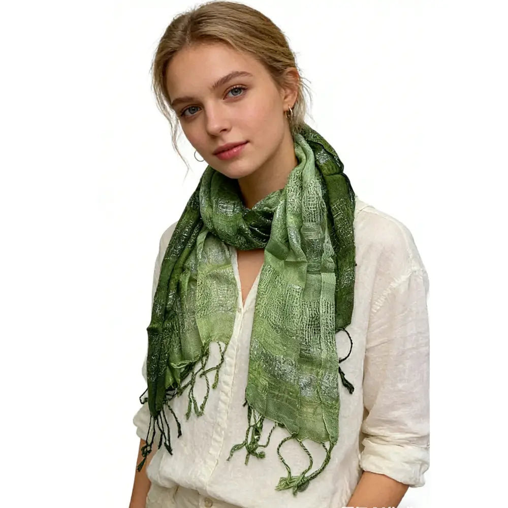 A soft olive green metallic shimmer silk scarf with a subtle textured pattern and fringed edges.