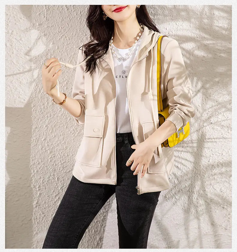 Beige Kapuzen-Cropped-Jacke mit vorderem Reißverschluss, Kordelzugkapuze und Fronttaschen, ausgelegt für den legeren Gebrauch.
