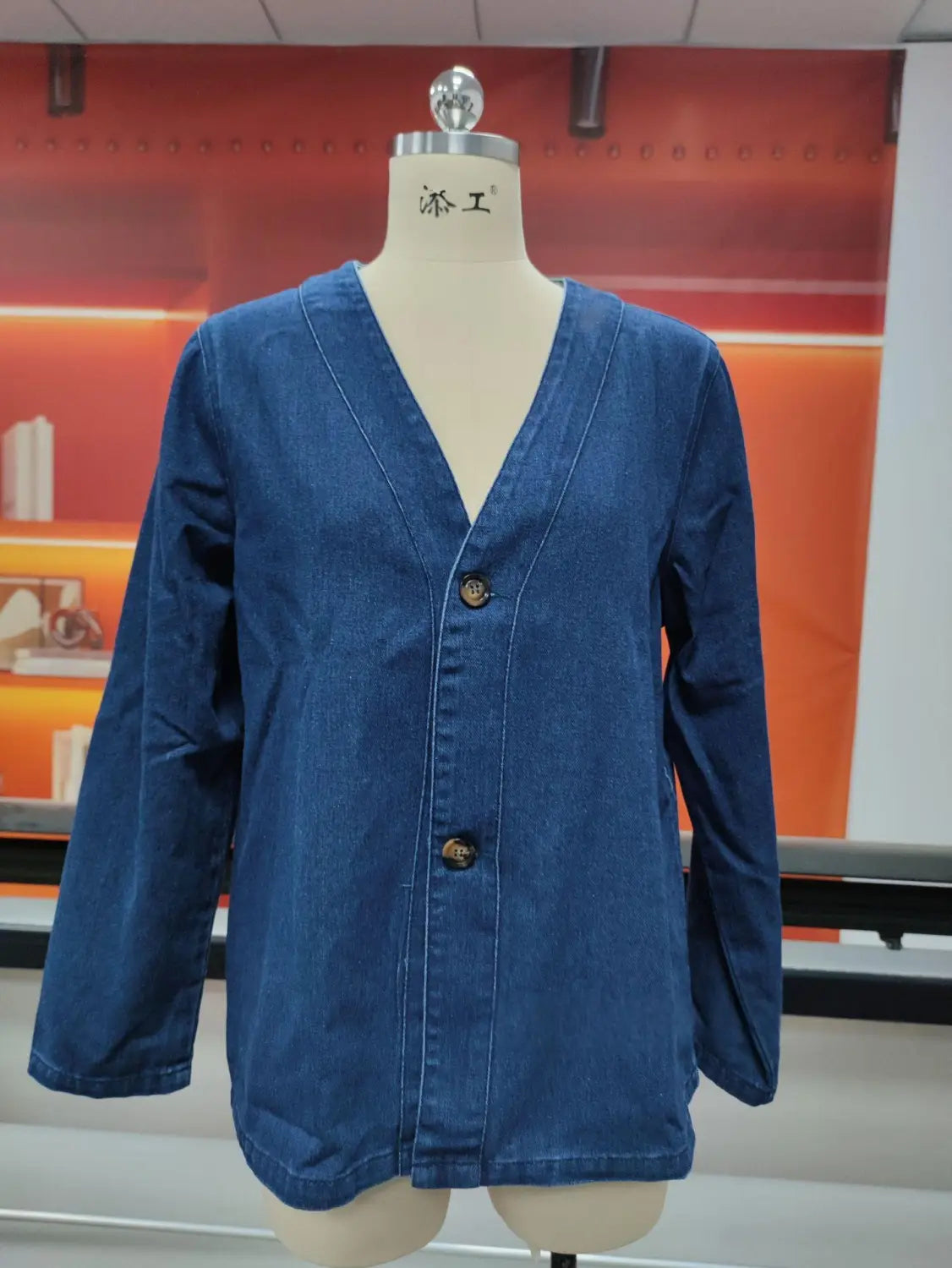 Chaqueta tipo cárdigan de mezclilla azul para mujer con cuello en V y tres botones marrón oscuro, en un estilo abotonado.