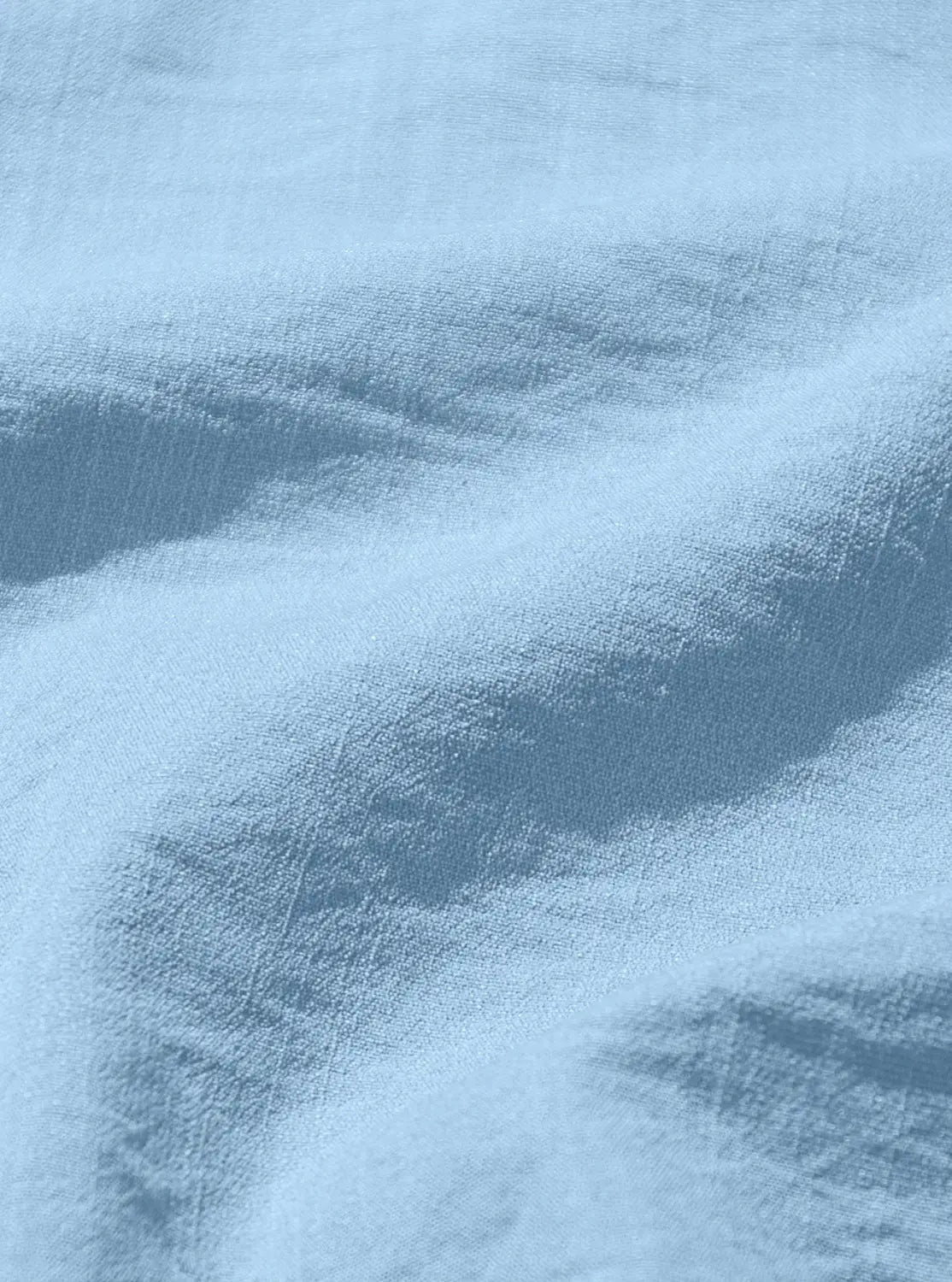 Light blue denim fabric with a soft slightly worn texture featured in a men’s textured bamboo linen short sleeve button down shirt.