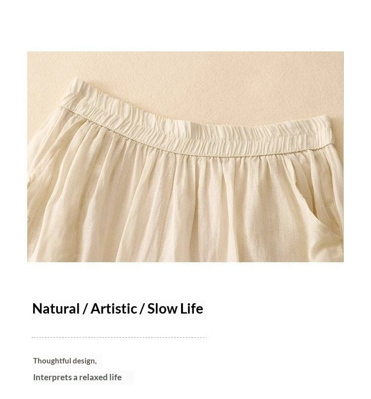 Ein cremefarbener leichter Baumwollrock mit elastischem Bund und weichen Falten, dargestellt von vorn, in Kombination mit bestickten Baumwoll-Leinen-Wide-Leg-Hosen.