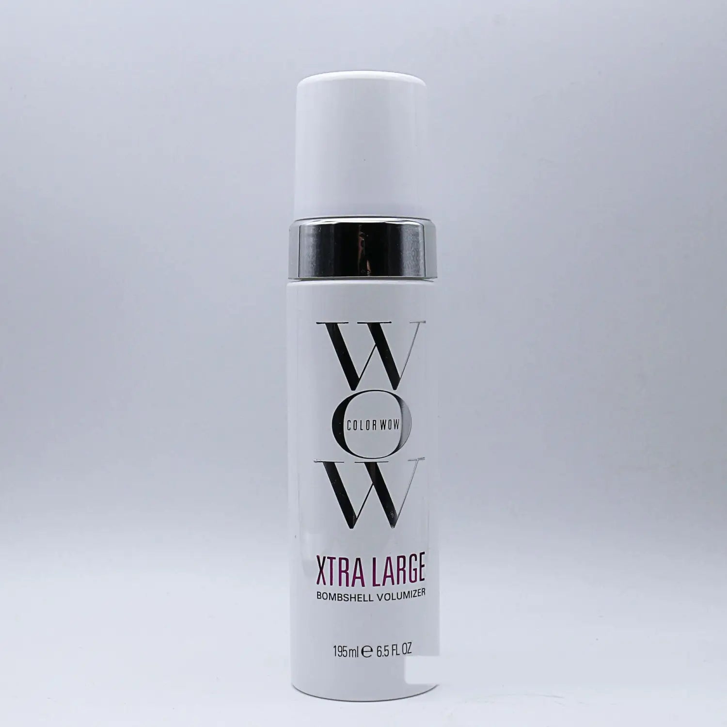 White cylindrical bottle with silver cap and black lettering labeled color wow xtra large bombshell volumizer hair mousse in purple text for volumizing hair.