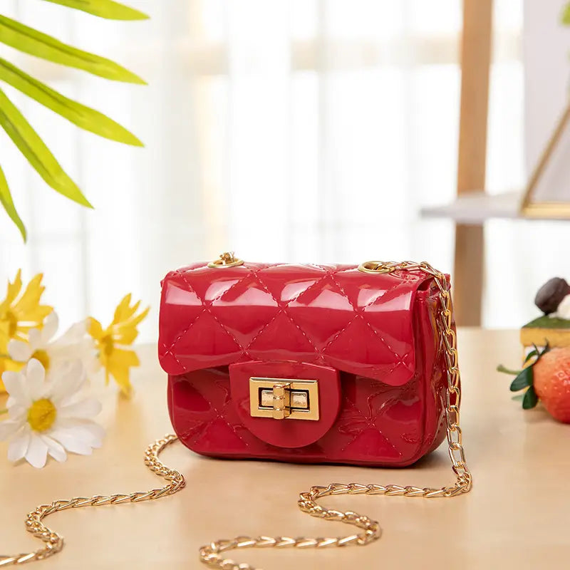 Vibrant red mini quilted patent leather crossbody bag for women with gold-tone chain strap and clasp.