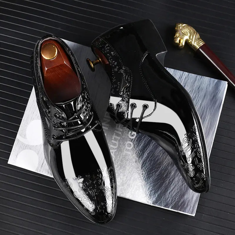 Embossed patent leather men’s formal business shoes in black with white stripe accents and intricate silver embossed patterns.