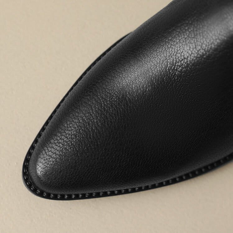 Black leather women’s block heel loafer with pointed toe and fine stitching along the edge.