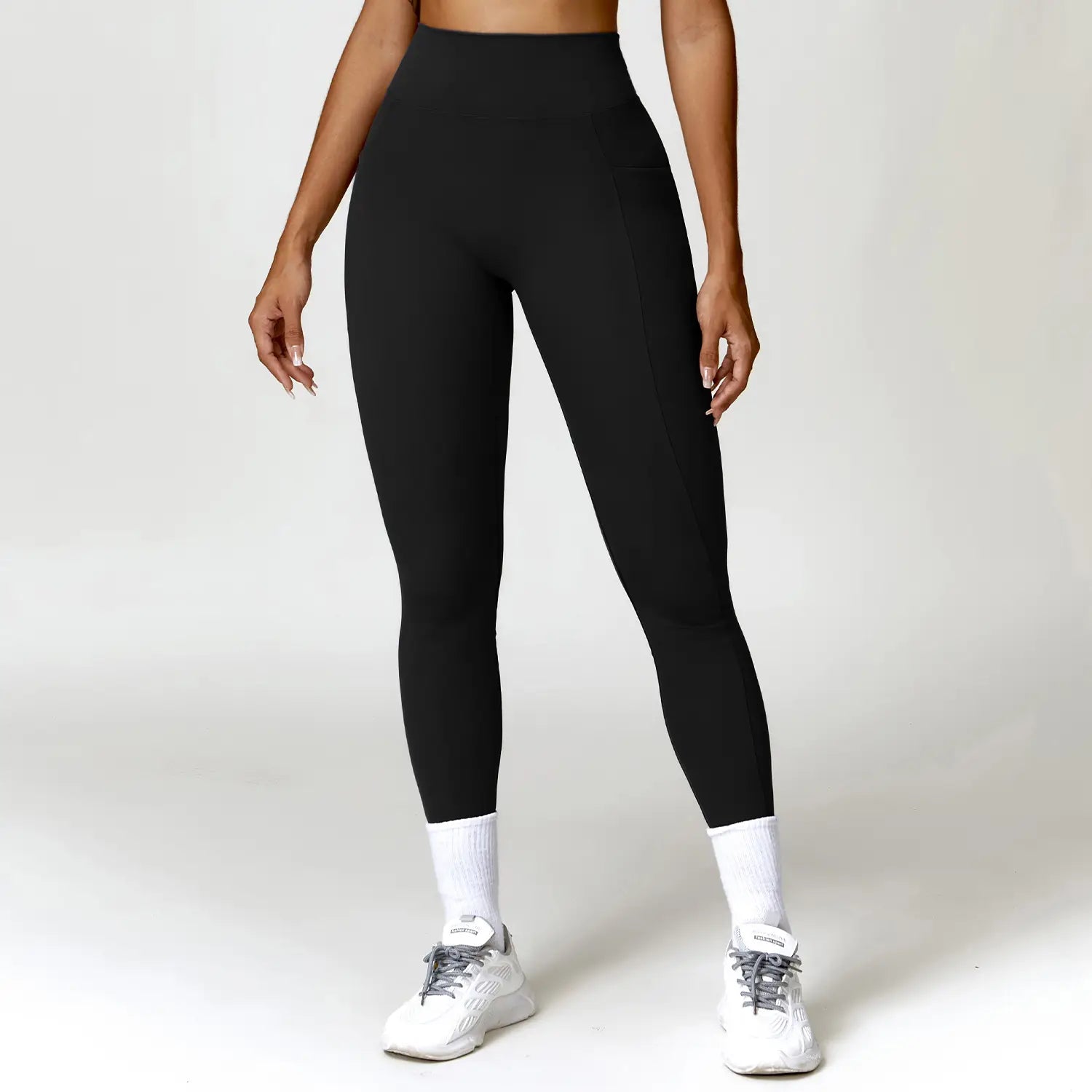 Elite high waisted athletic leggings in black feature a sleek form-fitting design with subtle side pockets ideal for athletic use.
