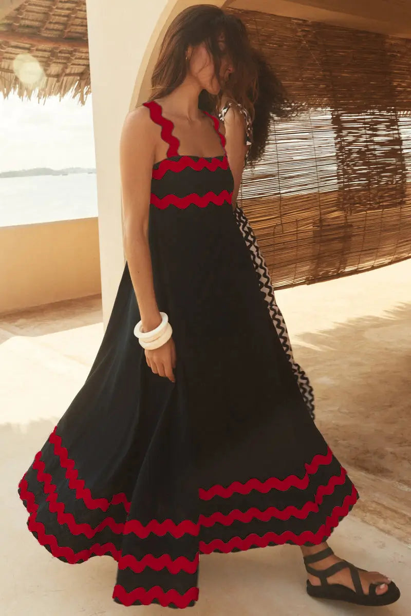 Vestido maxi negro con ribete zigzag rojo intenso a lo largo del escote, la pretina y la línea del bajo, en un vestido maxi de playa en corte A con ribete ondulado floral.
