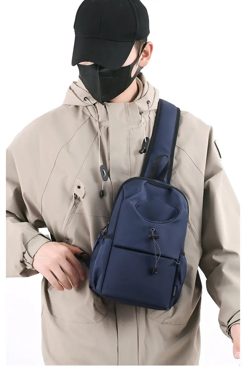 Dunkelblaue wasserdichte Herren-Oxford-Gewebe-Minimalist-Crossbody-Brusttasche aus Nylon mit schwarzen Reißverschlussgriffen und einer vorderen Tasche, gesichert mit einem Kordelzug-Verschluss.