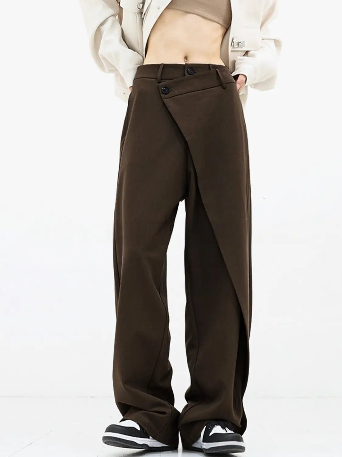Braune Weitbein-Hosen mit modernem asymmetrischem Frontdesign und Knopfleisten in einem taillierten Stoff, geeignet für zeitgemäße Mode.