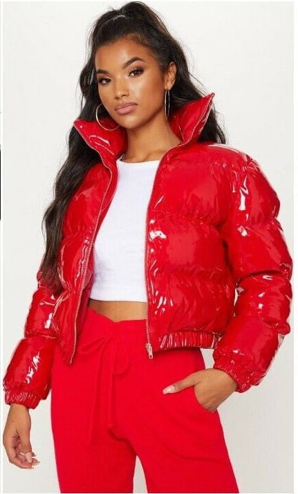 A shiny red glossy puffer jacket with a high collar elastic cuffs and cotton padding designed for women to stay warm.