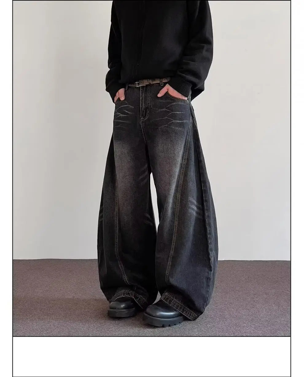 Men’s premium relaxed wide leg denim jeans in black with a faded distressed look and raw hem made from denim material.
