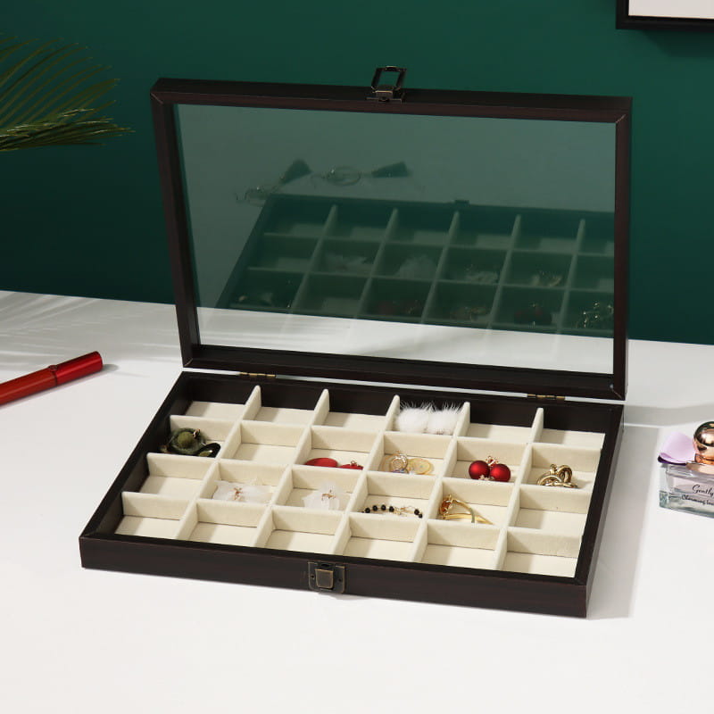 Dark brown rosewood jewelry display box with glass lid and cream-colored interior compartments.