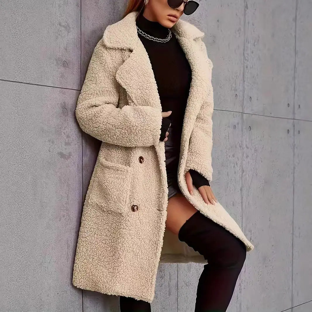 Manteau teddy mi-long doublé en polaire de couleur crème, présentant une texture moelleuse et un design classique à double boutonnage.