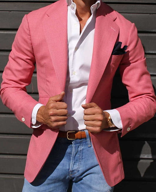 Herren-Karos-Blazer Slim Fit, taillierter Casual-Jackenschnitt mit einem lebhaften pinkfarbenen, strukturierten Webmuster, über ein weißes Hemd getragen und mit Jeans kombiniert.