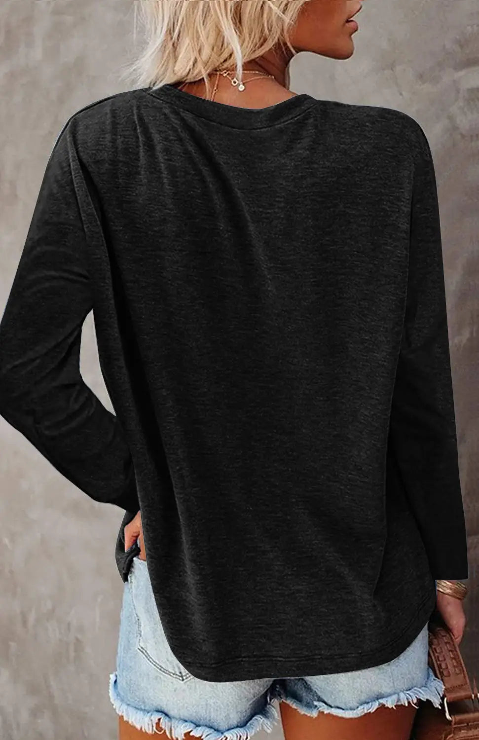 Black relaxed pocket knit long sleeve t-shirt with a subtle heathered texture and a comfortable fit.