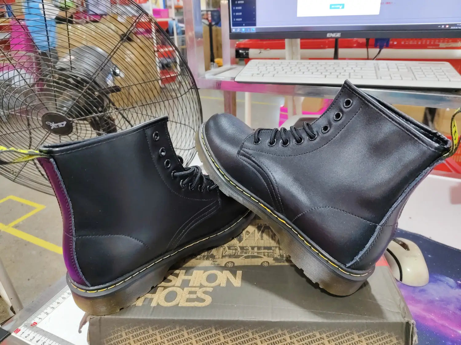 Black leather Martin boots featuring burgundy color and yellow stitching shown from the back side.