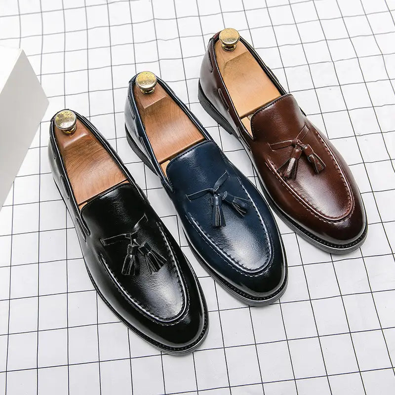 Three pairs of polished leather tassel loafers in black navy blue and brown designed as slip on shoes.