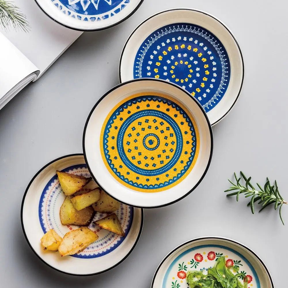 Ceramic floral bone china round serving plate set with bold blue and yellow concentric circular patterns on a white background.