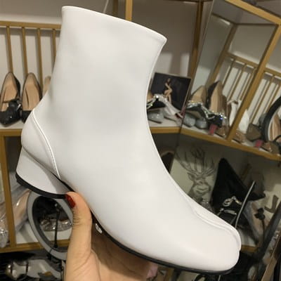 White leather split toe tabi ankle boot with a sleek minimalist design and low block heel shown from the back side.