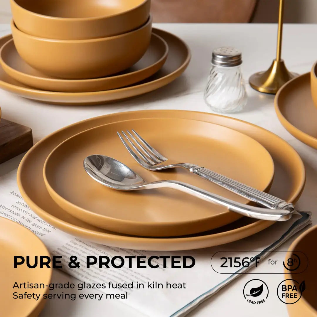 Set of 12 piece warm terracotta-colored stoneware dinnerware with matte glaze featuring matching bowls and plates with a smooth glazed finish for four people.