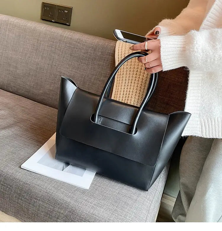 black leather tote bag with a vintage structured minimalist design and sleek top handles