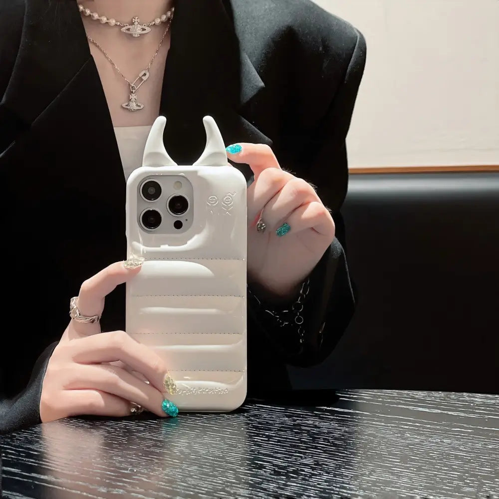 white quilted leather iphone case with horn-like protrusions and subtle embossed details shown from the back side