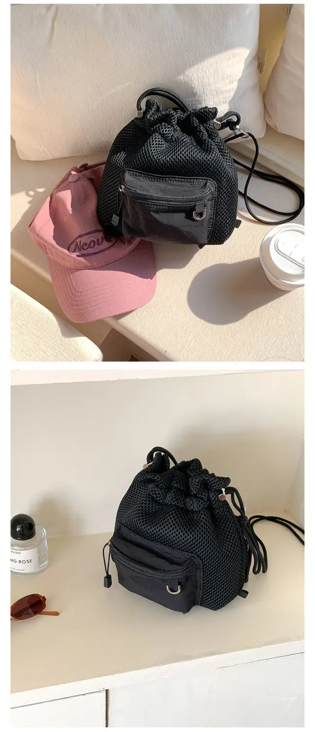 Black mesh drawstring backpack with a front pocket and adjustable strap featured as a mini pink mesh drawstring bucket bag with heart charm.