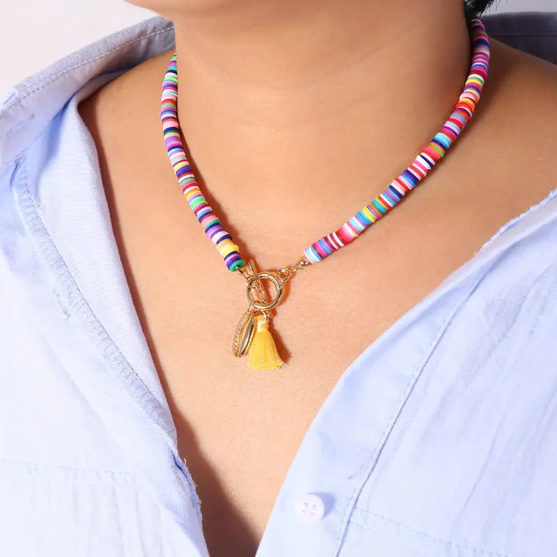 Bohemian rainbow beaded choker featuring multicolored beads with a gold-toned toggle clasp and a yellow tassel charm.