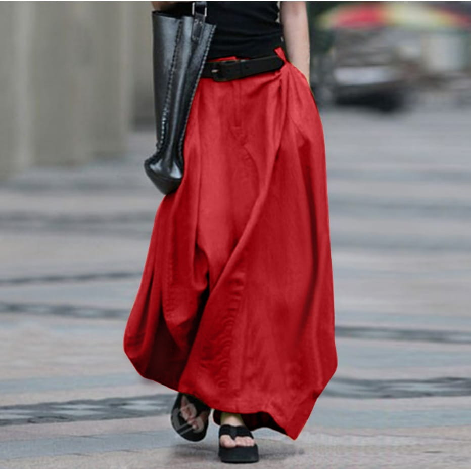 Une jupe longue maxi en satin taille haute rouge vif et fluide, avec une silhouette ample de type ballon et des plis subtils.