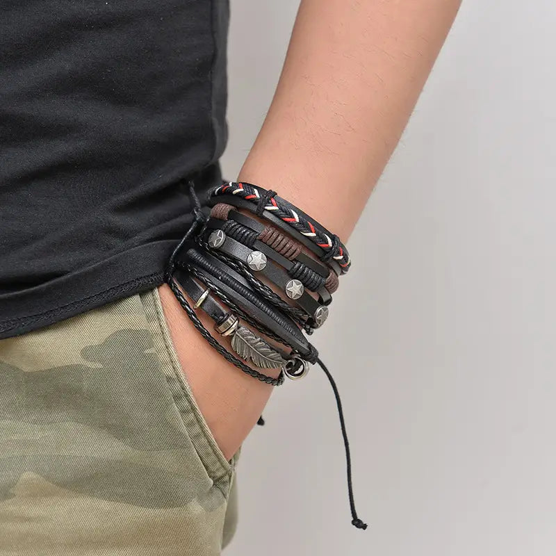 Men’s multilayer black leather bracelet featuring silver star and feather charms stacked for a stylish look.